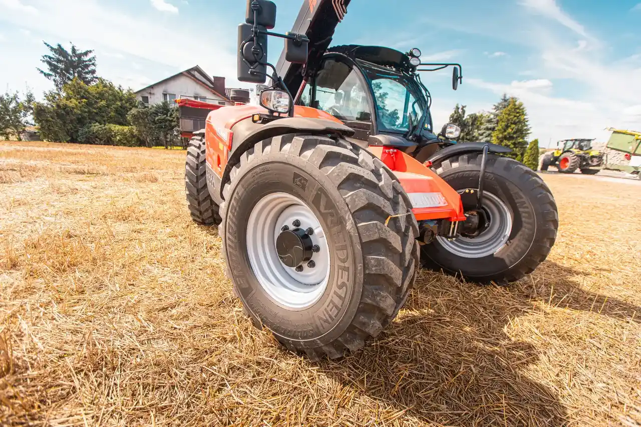 Ładowarka teleskopowa Manitou podnosi balot słomy